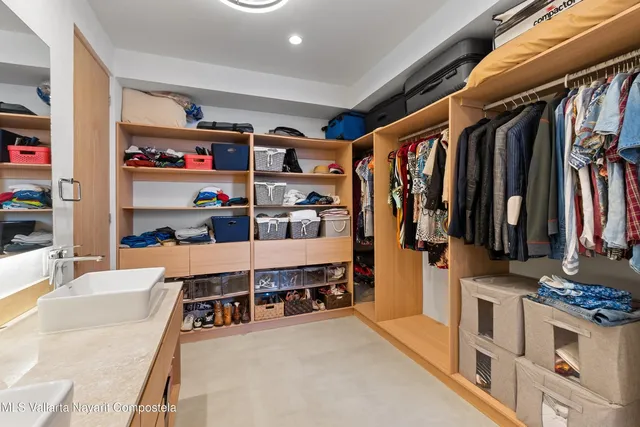 a view of walk in closet with clothes and shoes