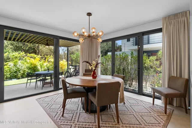a dining room with wooden floor a chandelier a glass table and chairs