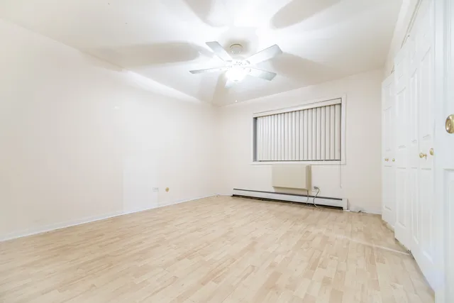 an empty room with windows and fan