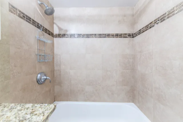 a bathroom with a granite countertop toilet and a sink