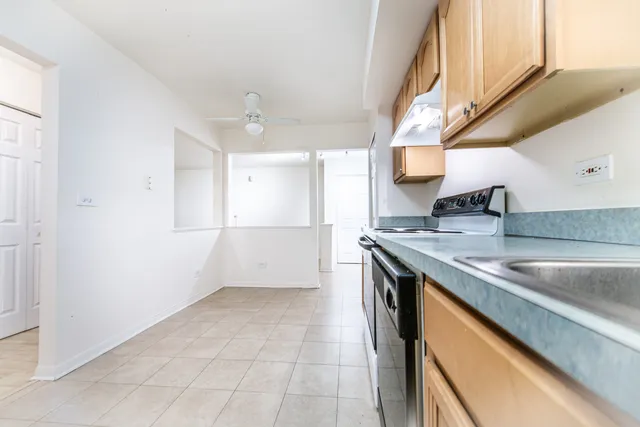a kitchen with granite countertop a sink and a refrigerator