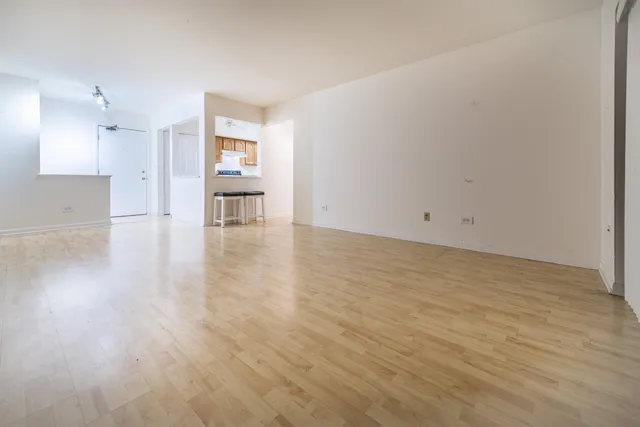 a view of empty room with wooden floor