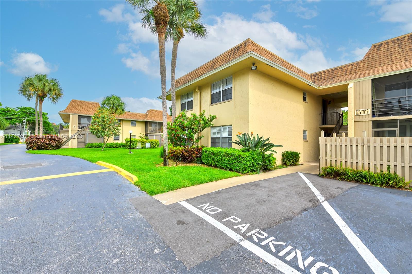 a front view of a house with a garden and trees