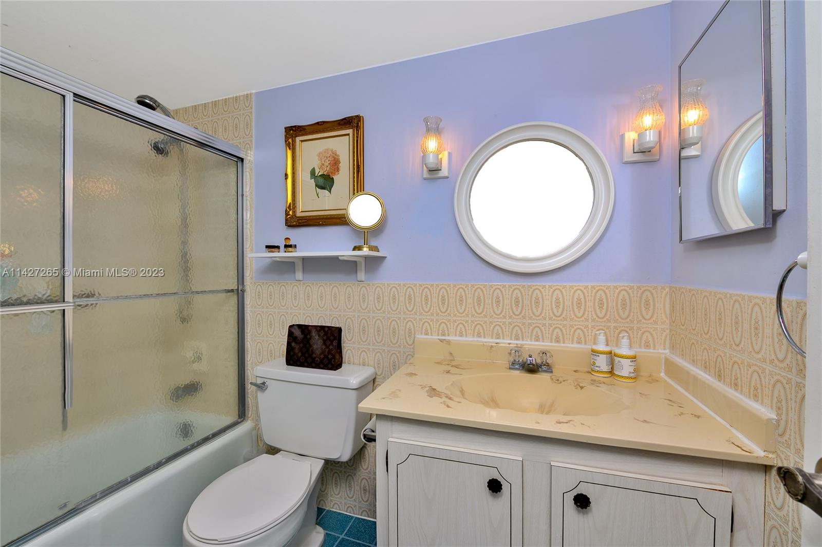 1231 Northwest 13th Street, Unit 472F Boca Raton, FL 33486 - Photo 12 of 22 a bathroom with a granite countertop toilet sink and mirror