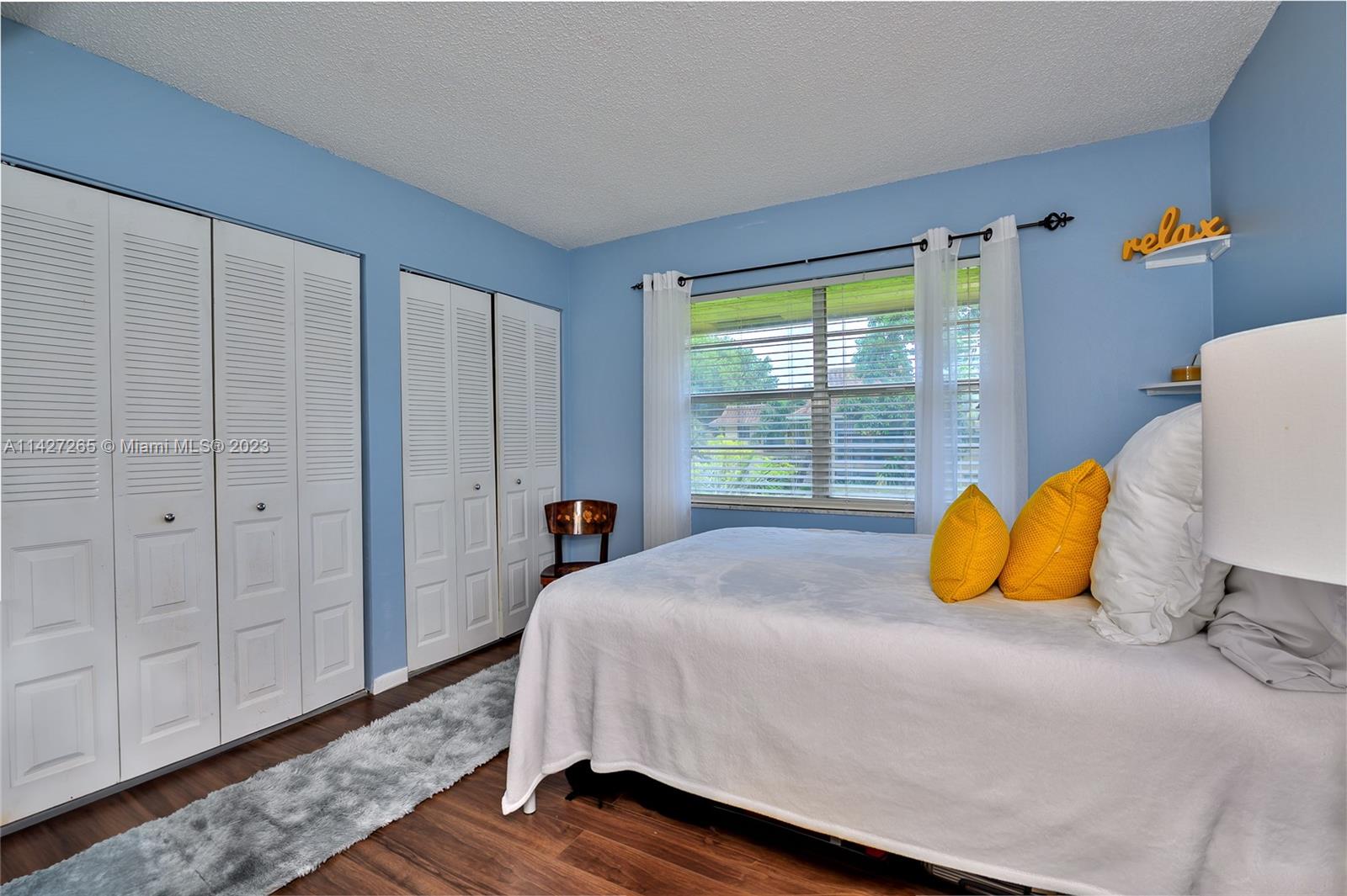 1231 Northwest 13th Street, Unit 472F Boca Raton, FL 33486 - Photo 13 of 22 a bedroom with a bed and wooden floor