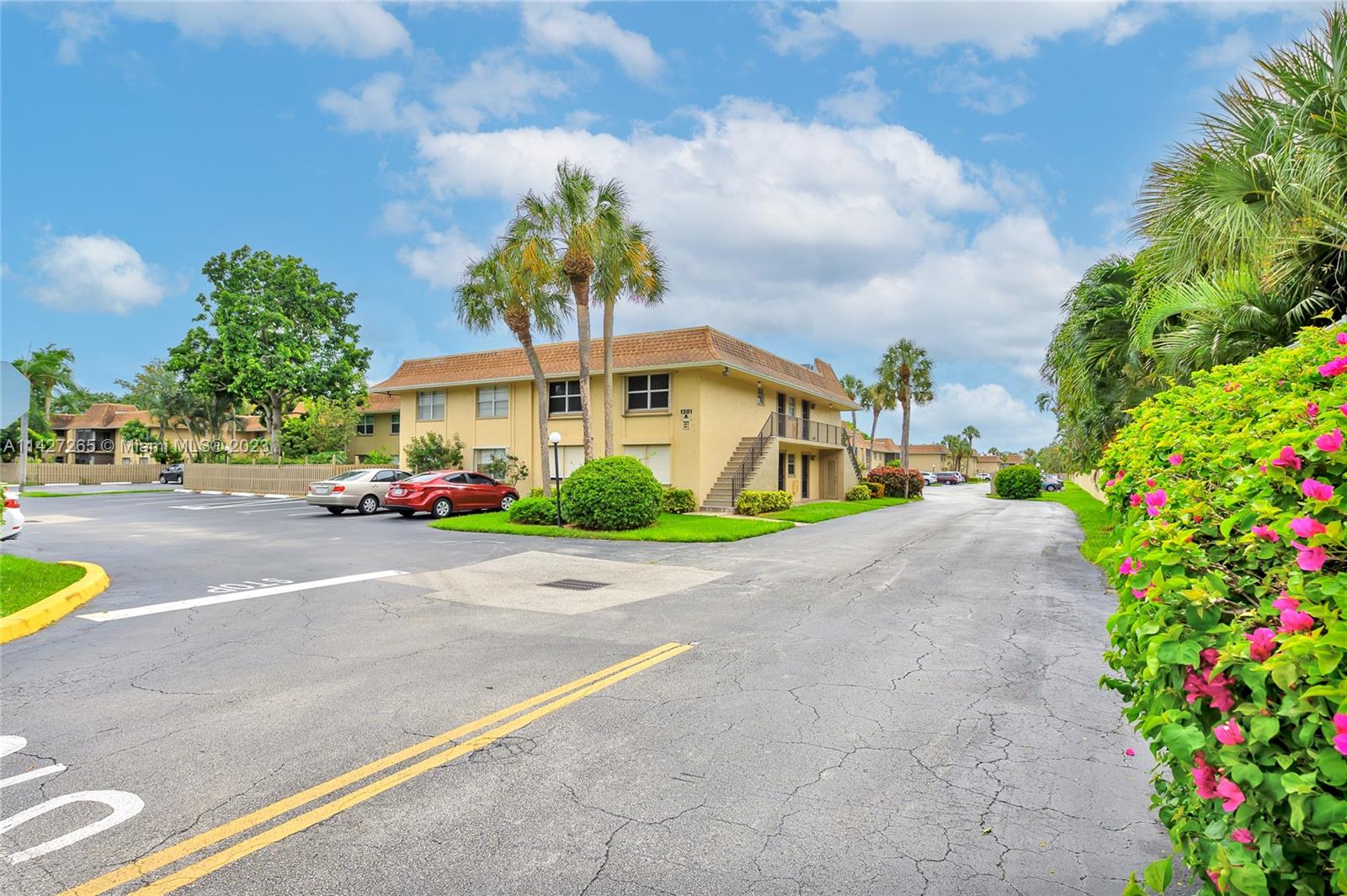 1231 Northwest 13th Street, Unit 472F Boca Raton, FL 33486 - Photo 4 of 22 a city street lined with buildings and trees