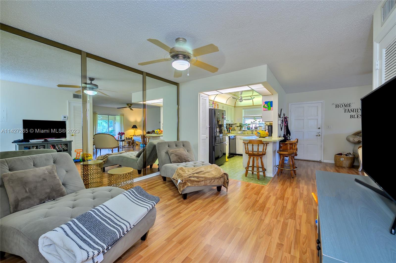 1231 Northwest 13th Street, Unit 472F Boca Raton, FL 33486 - Photo 8 of 22 a living room with furniture and a flat screen tv