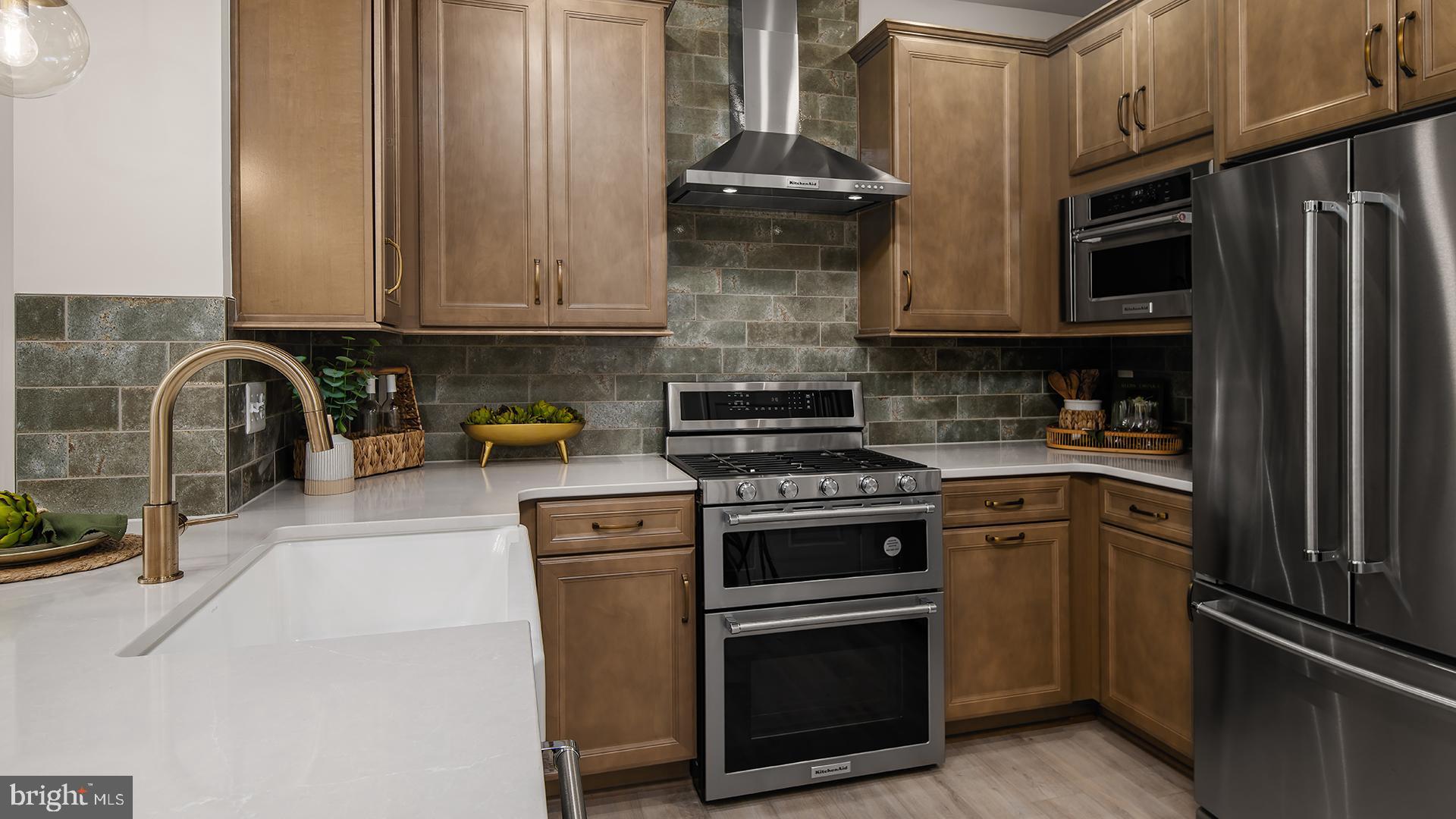 Tbb Cloongee Terrace, Unit ROSSLYN Sterling, VA 20166 - Photo 7 of 14 a kitchen with stainless steel appliances granite countertop a stove a refrigerator and a sink with wooden cabinets