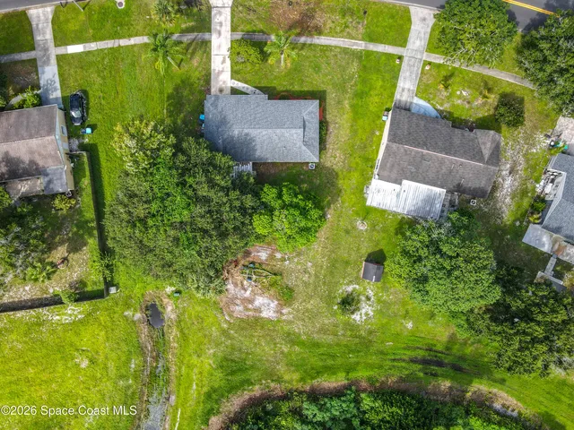 an aerial view of residential house with an outdoor space and tennis court