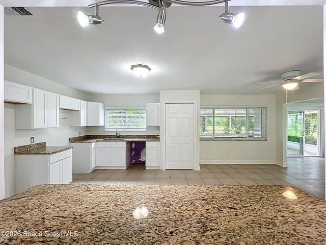 a kitchen with stainless steel appliances granite countertop a sink stove and white cabinets