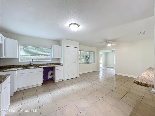 a large white kitchen with a sink and cabinets