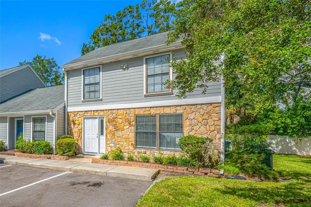 a front view of a house with a yard and potted plants
