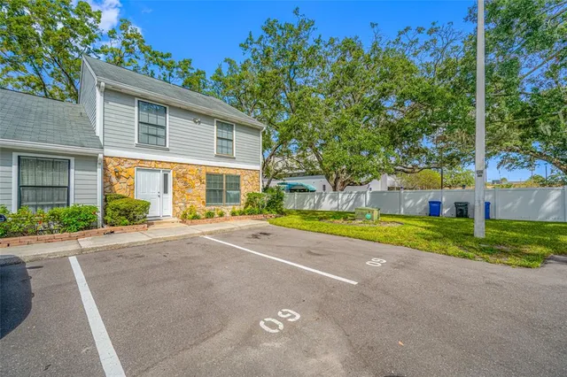a view of a house with a big yard and large trees