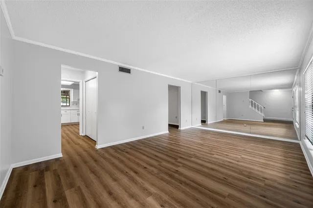 a view of an empty room with wooden floor