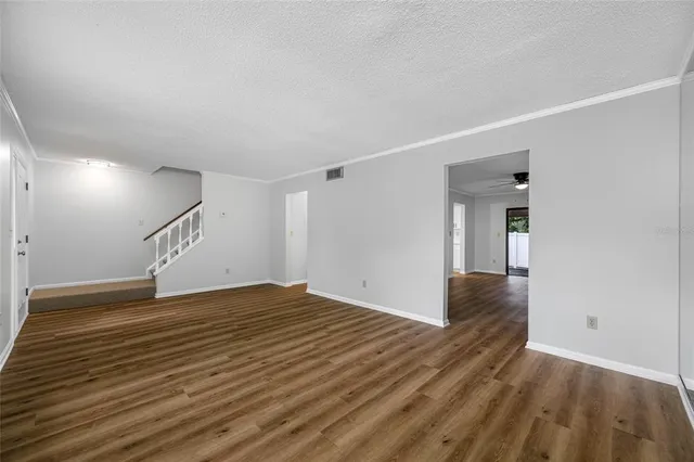 a view of empty room with wooden floor