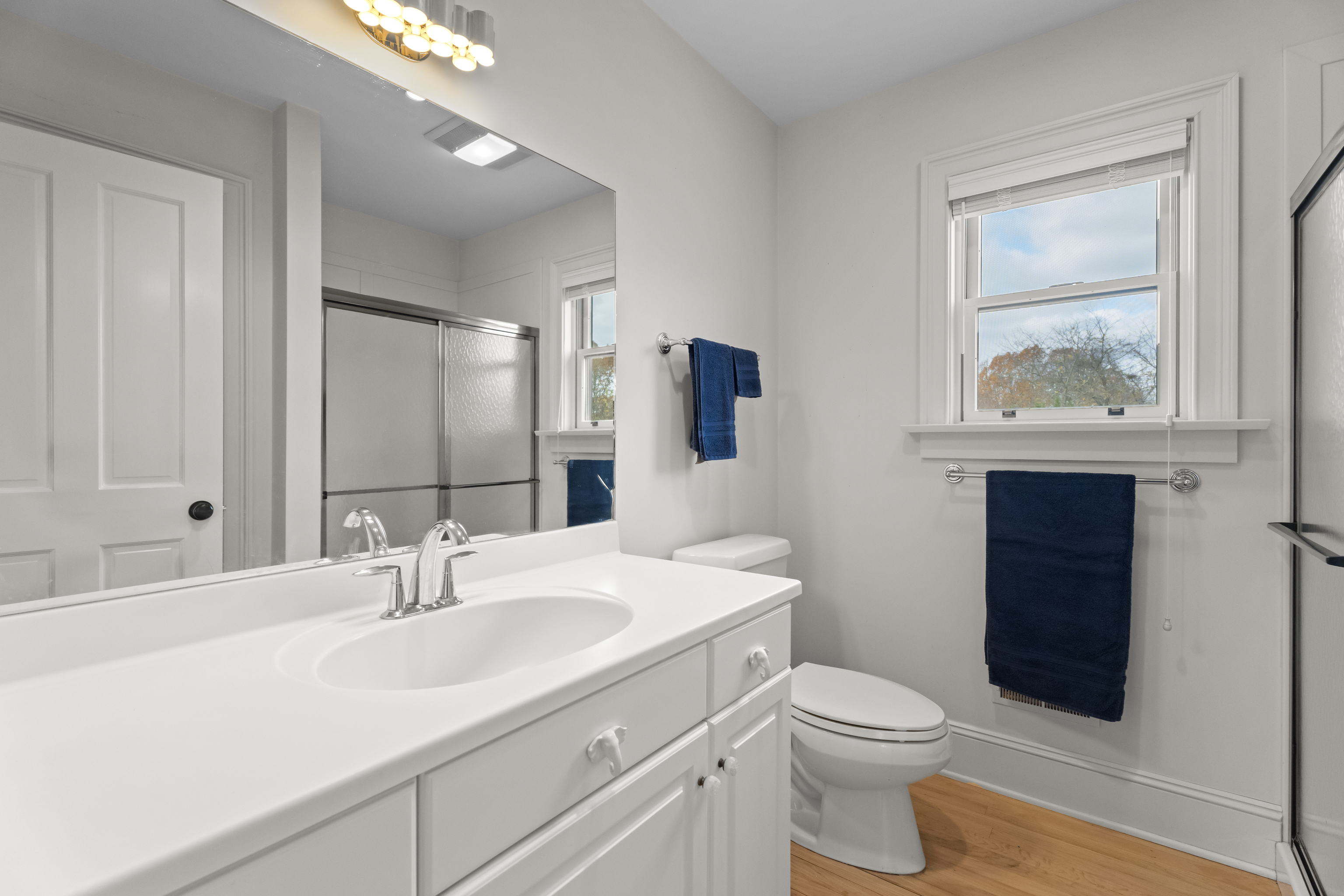 4 East Neck Road Stonington, CT 06378 - Photo 23 of 40 a bathroom with a toilet a sink a vanity and mirror
