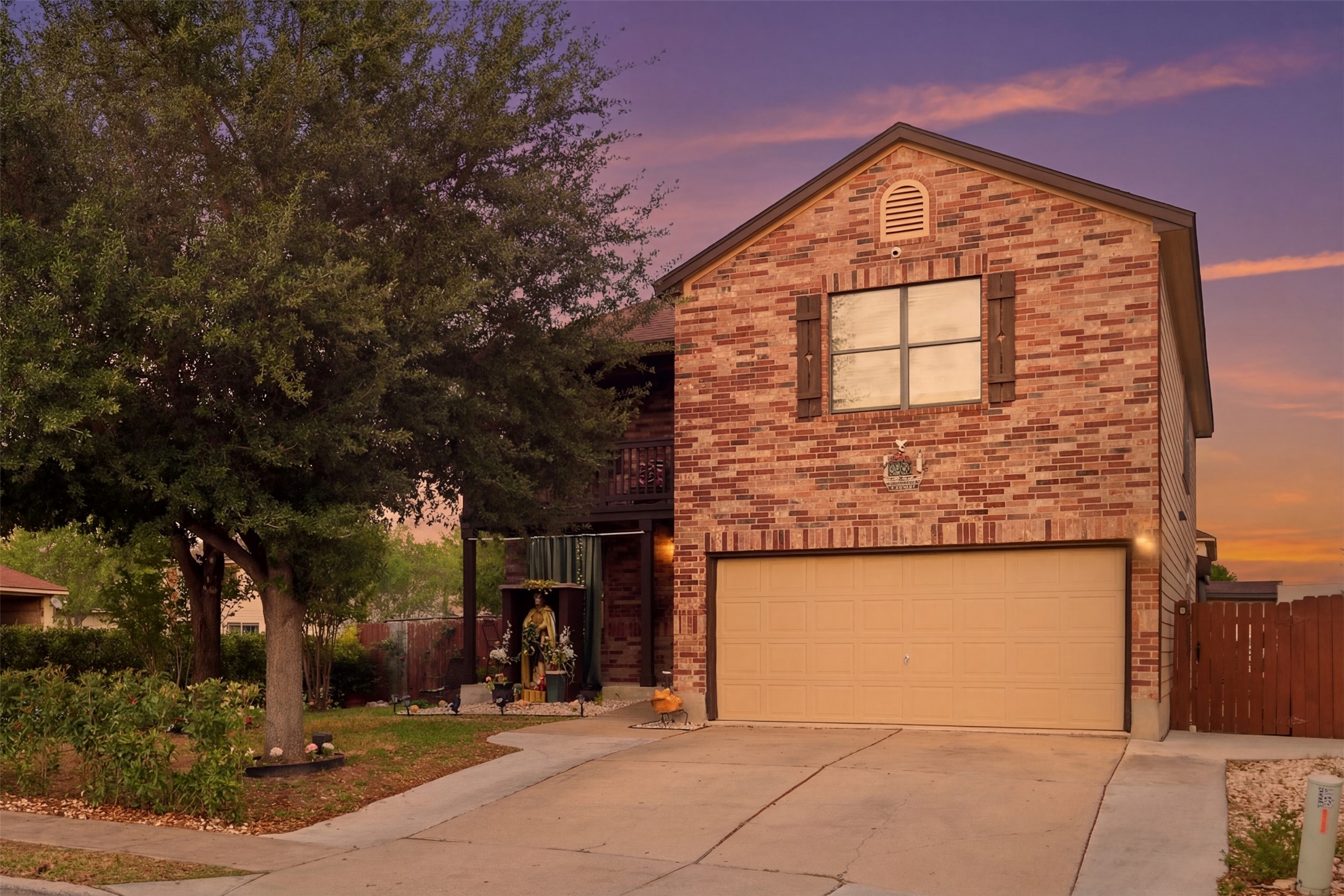 5701 Malarkey Road Del Valle, TX 78617 - Photo 1 of 27 View of front of property with a balcony, an attached garage, concrete driveway, and brick siding