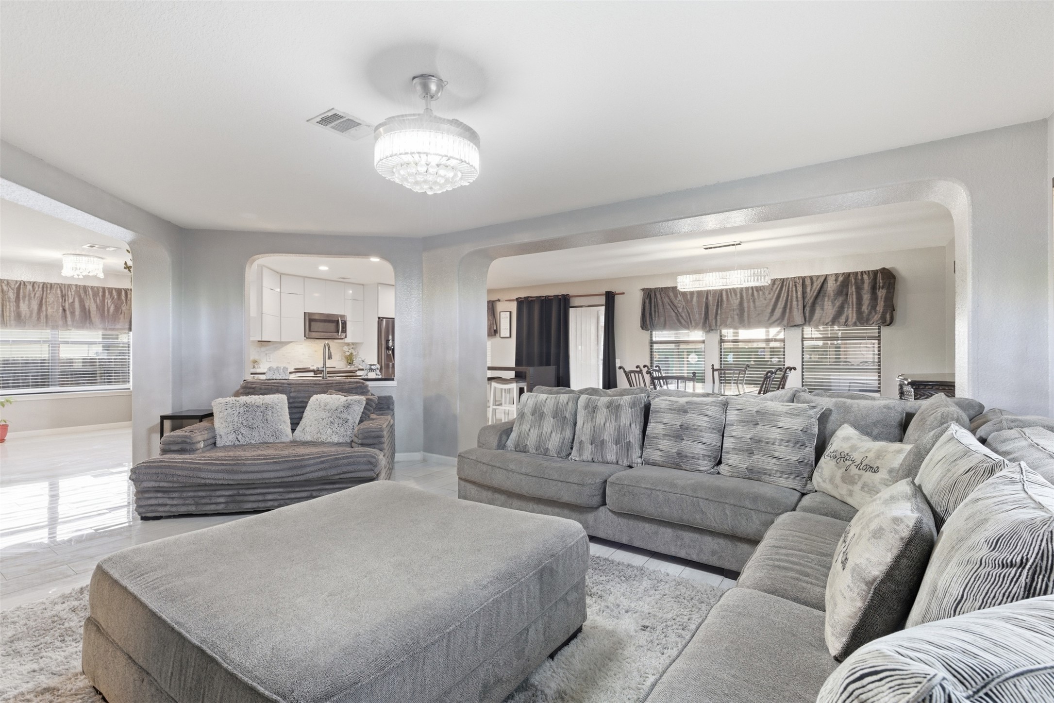 5701 Malarkey Road Del Valle, TX 78617 - Photo 10 of 27 Living room with healthy amount of natural light, arched walkways, and suspended lighting