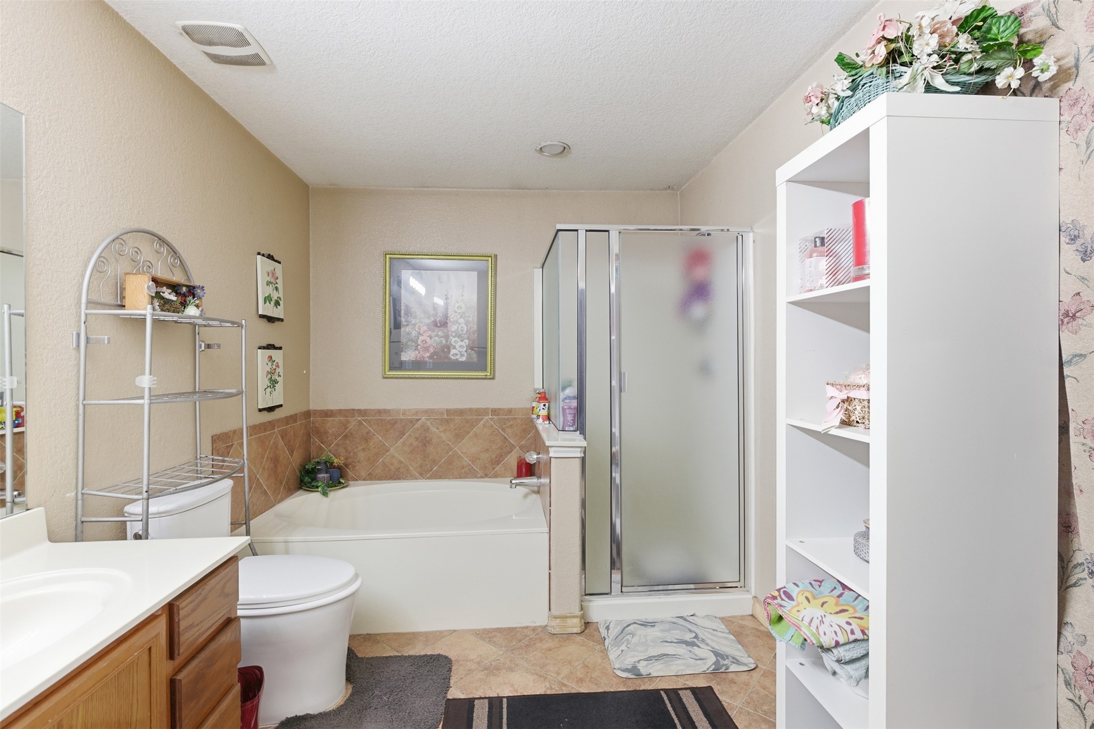 5701 Malarkey Road Del Valle, TX 78617 - Photo 20 of 27 Full bath featuring vanity, a stall shower, a bath, a textured ceiling, and light tile patterned flooring