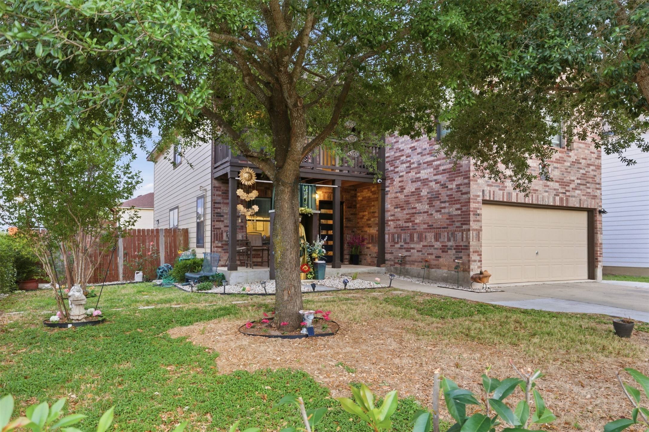 5701 Malarkey Road Del Valle, TX 78617 - Photo 3 of 27 View of front of home with brick siding, concrete driveway, a patio area, and an attached garage
