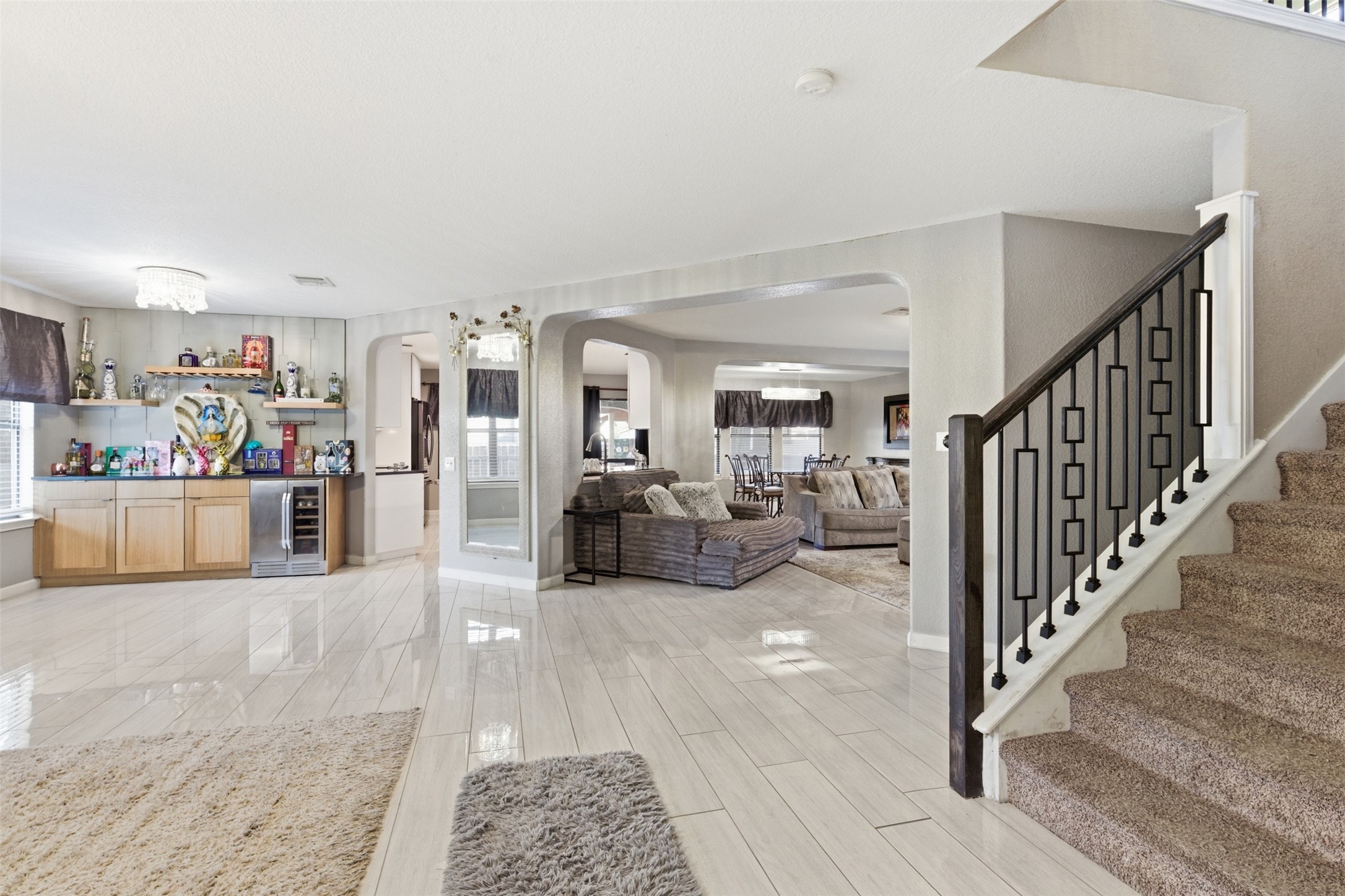 5701 Malarkey Road Del Valle, TX 78617 - Photo 5 of 27 Living area featuring arched walkways, bar, wine cooler, and wood tiled floors