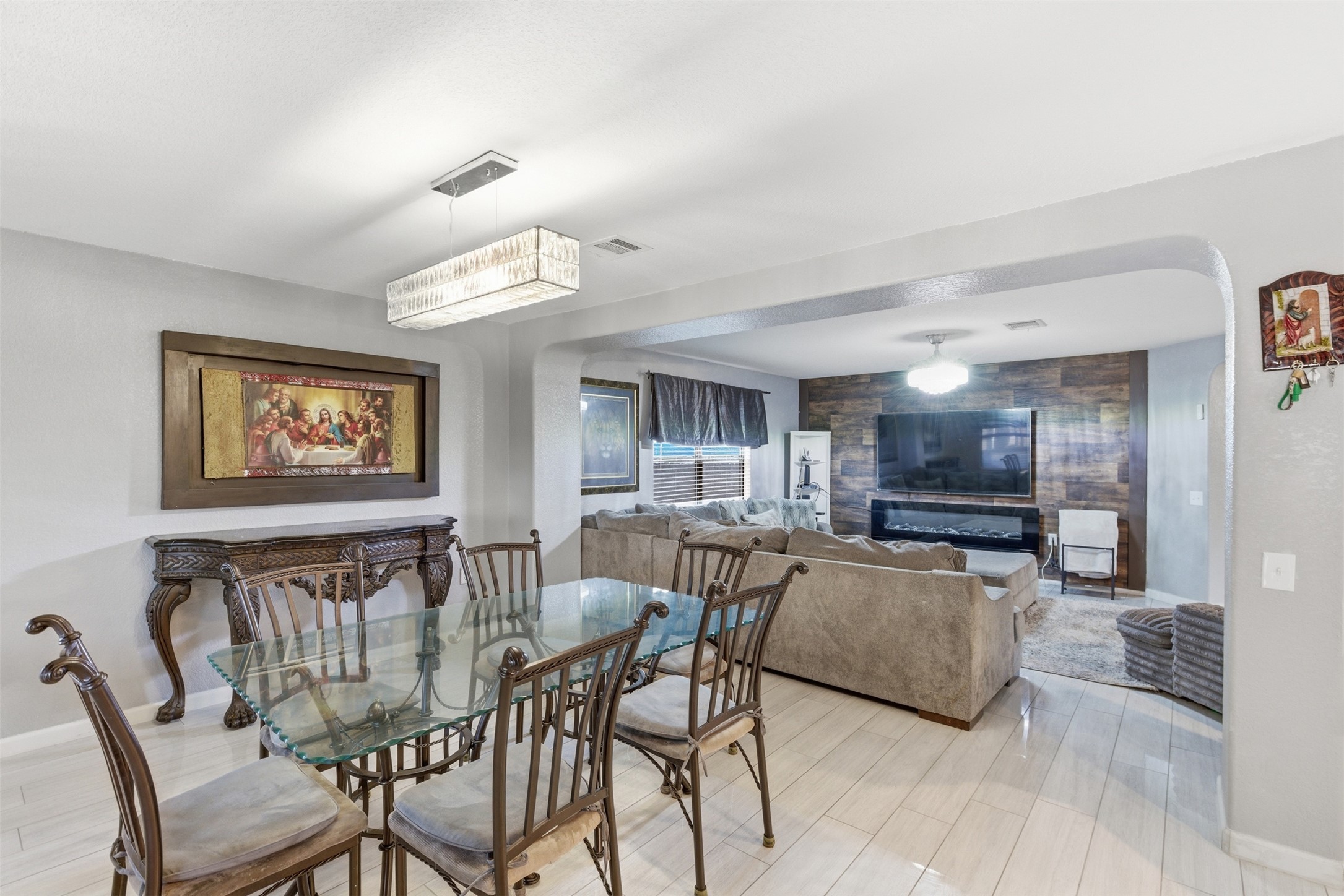 5701 Malarkey Road Del Valle, TX 78617 - Photo 6 of 27 Dining space featuring arched walkways, an accent wall, and light wood-style flooring