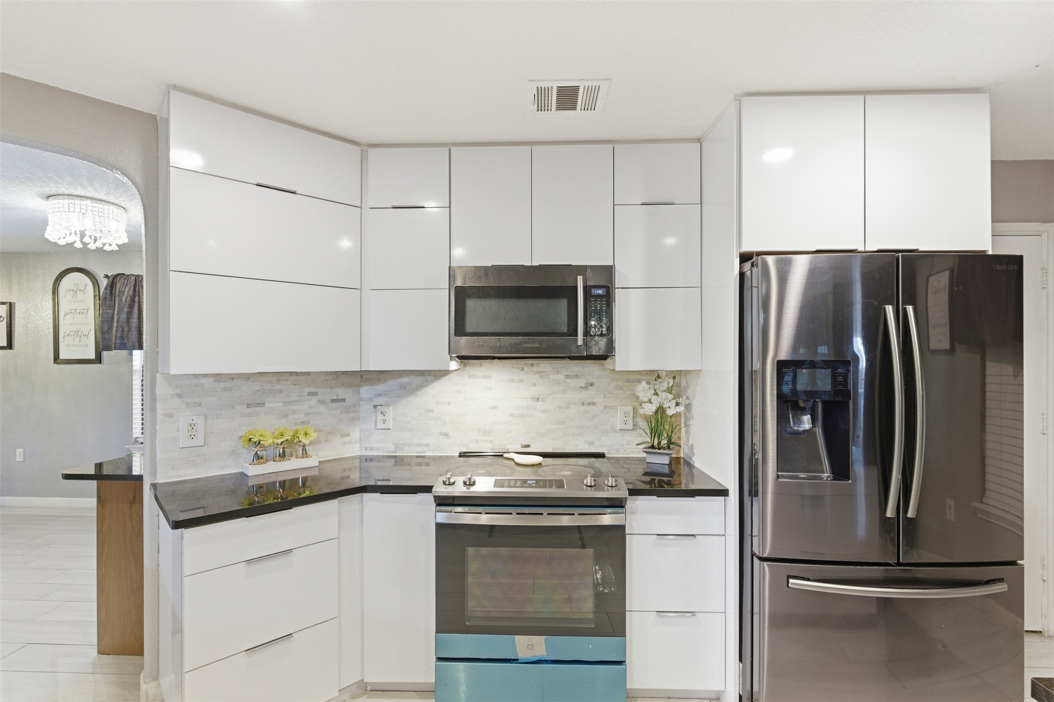 5701 Malarkey Road Del Valle, TX 78617 - Photo 8 of 27 Kitchen with modern cabinets, stainless steel appliances, and white cabinets