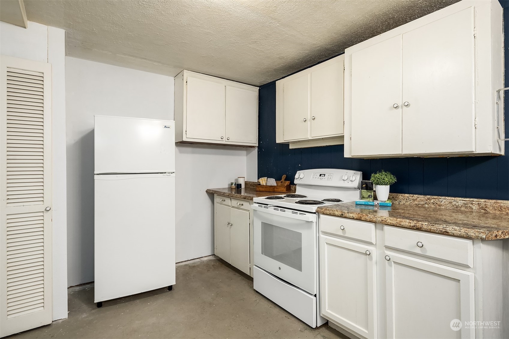 201 Thomas Avenue Southwest Renton, WA 98057 - Photo 21 of 38 a kitchen with a refrigerator and white cabinets