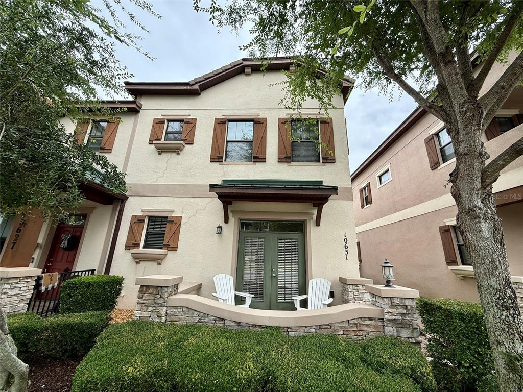 a view of white house with a yard and potted plants