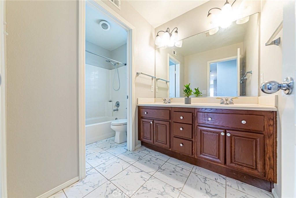 17645 Loganberry Road Carson, CA 90746 - Photo 31 of 56 a spacious bathroom with a granite countertop sink a toilet and a mirror