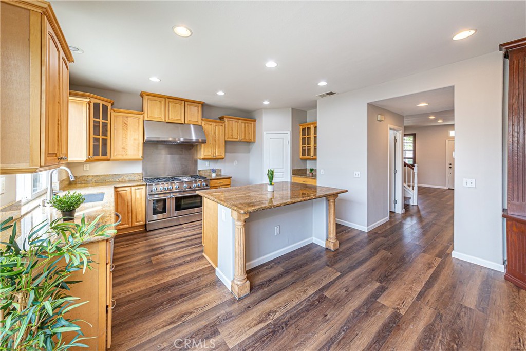 17645 Loganberry Road Carson, CA 90746 - Photo 8 of 56 a kitchen with stainless steel appliances kitchen island granite countertop a stove a sink and a refrigerator