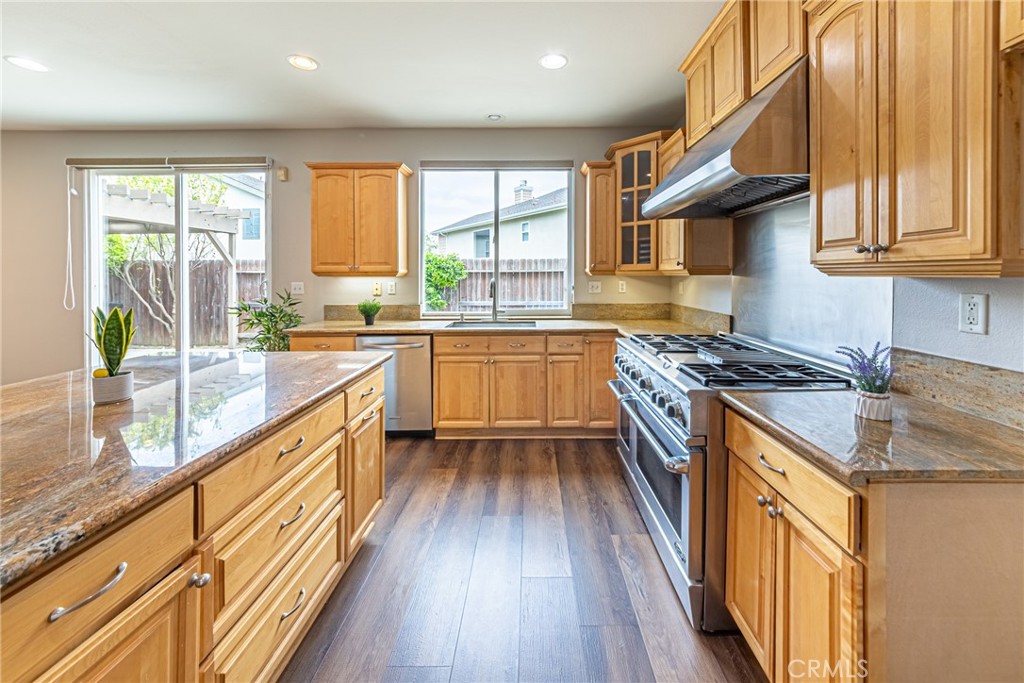 17645 Loganberry Road Carson, CA 90746 - Photo 10 of 56 a kitchen with stainless steel appliances granite countertop a stove a sink and a refrigerator