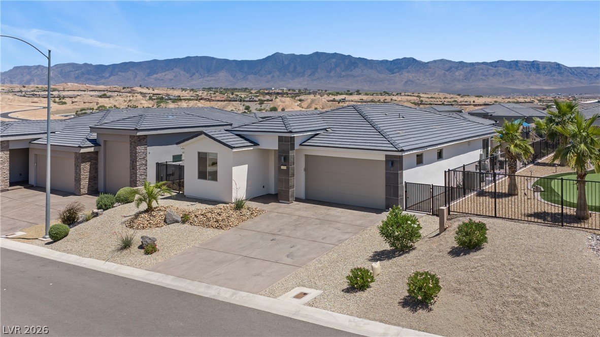1436 Manassas Ridge Mesquite, NV 89027 - Photo 73 of 77 Modern desert architecture with a spacious driveway and mountain backdrops.