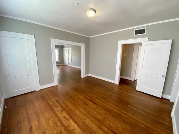an empty room with wooden floor and closet