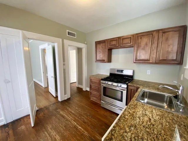 a kitchen with granite countertop wood cabinets and stainless steel appliances