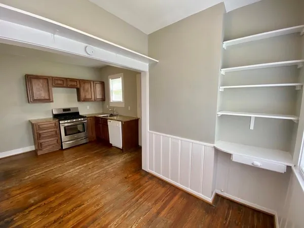 a kitchen with granite countertop a stove and a wooden floors