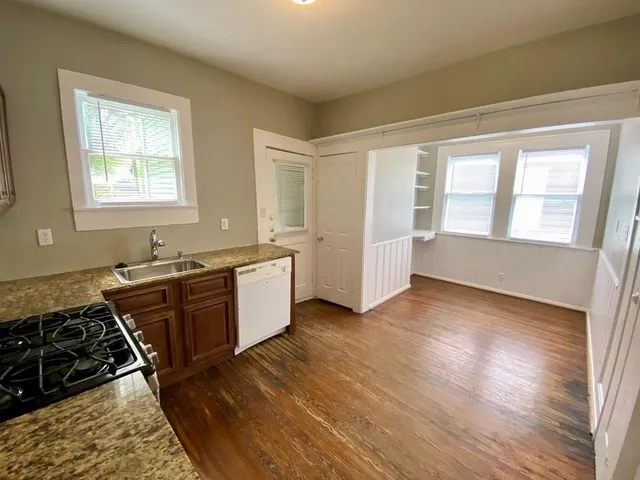 a large kitchen with a wooden floor and a stove top oven