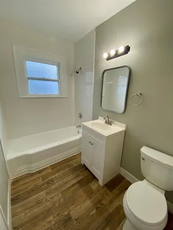 a bathroom with a toilet a sink and mirror