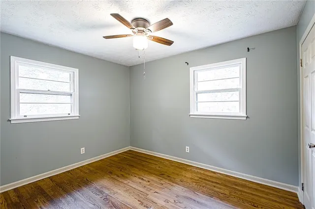 a view of a room with wooden floor and a window