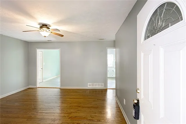 a view of a livingroom with a chandelier fan and wooden floor