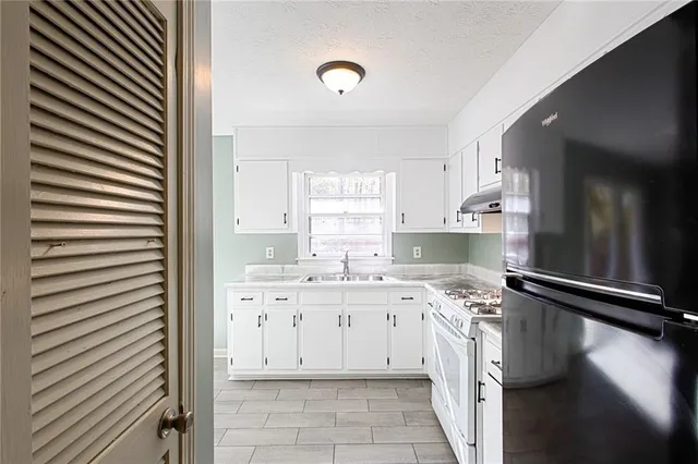 a kitchen with a sink stove and cabinets