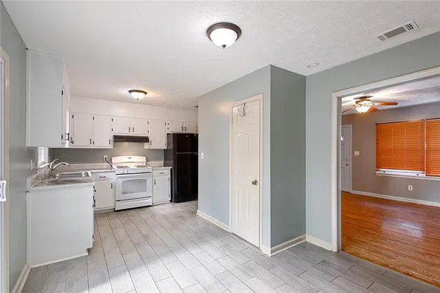 a kitchen with stainless steel appliances granite countertop a refrigerator and a stove top oven