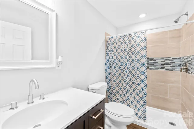 a bathroom with a sink a toilet and shower curtain