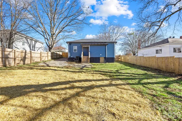 a view of a house with a yard covered with snow and trees