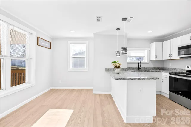 a kitchen with stainless steel appliances granite countertop a sink a stove a refrigerator and window