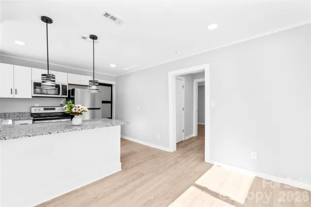 a view of kitchen with stainless steel appliances kitchen island sink stove and refrigerator