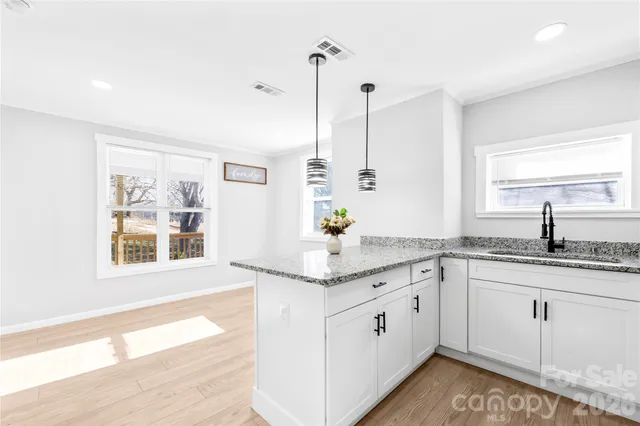 a kitchen with granite countertop white cabinets and white appliances