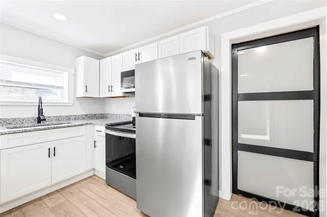a kitchen with stainless steel appliances a refrigerator sink and cabinets
