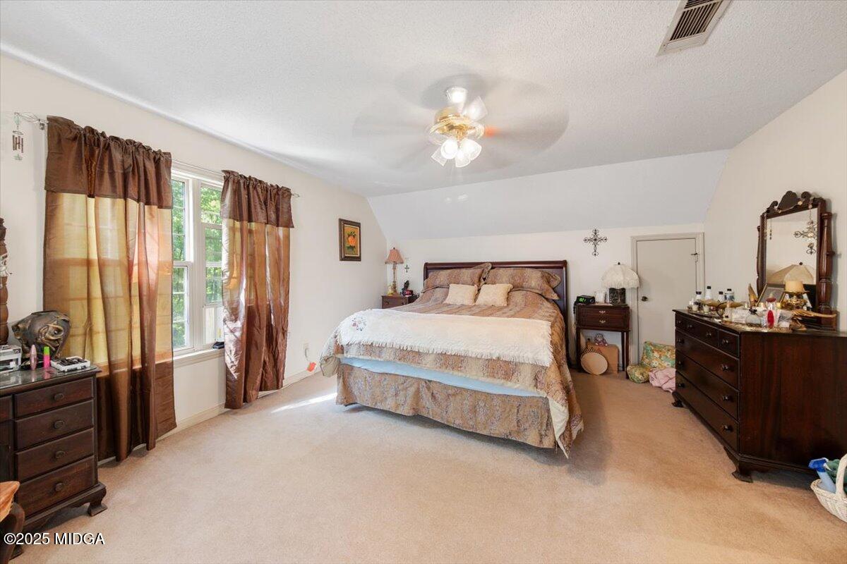 856 Lite-N-Tie Road Macon, GA 31211 - Photo 13 of 45 a spacious bedroom with a bed and a chandelier