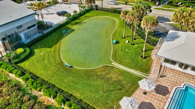a view of a patio with chairs and table under an umbrella with a garden